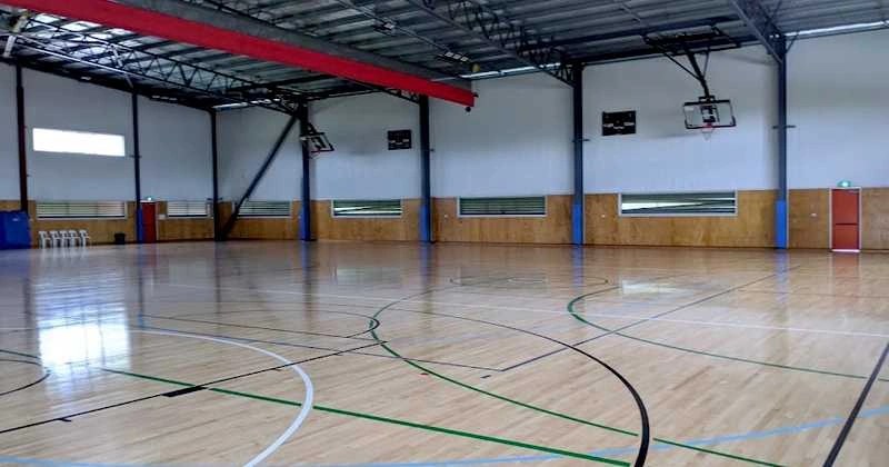 Empty indoor sprung sports court at Eagles Sports Complex with basketball hoops and multi-sport floor markings.
