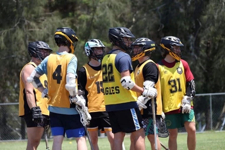 A group of junior players in yellow Eagles training vests gathered on the outdoor field.