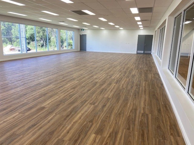 Light-filled multipurpose function room at Eagles Sports Complex with polished vinyl flooring and large windows.